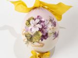 a white egg with purple flowers painted on it