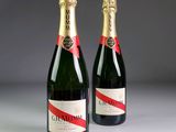 two bottles of champagne sitting next to each other on a table