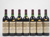 six bouteilles de vin sont alignées sur une surface blanche