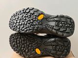 the soles of a pair of black hiking shoes on a cardboard box