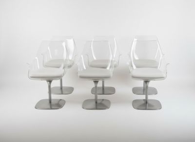 three white chairs sitting next to each other on top of a white floor