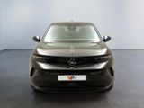 the front of a silver car in a room with a white wall