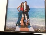 a picture of two people and a dog on the beach