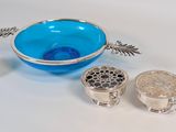 a blue bowl and two silver dishes on a white table