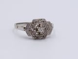 a close up of a diamond ring on a white surface