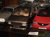 Plusieurs modèles réduits de voitures sont exposés dans une vitrine.