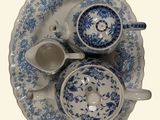 a picture of a blue and white plate with two cups and saucers