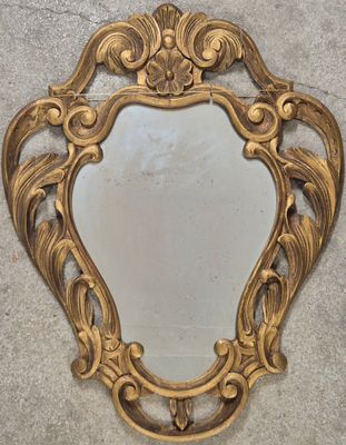 une image représentant un miroir avec un cadre doré accroché au mur