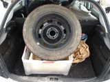 a tire in the back of a car with a box in the trunk