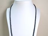 black beaded necklace on a white mannequin with a black bead
