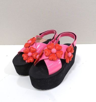 une paire de sandales roses et noires ornées de fleurs