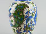 a blue and white vase with a peacock design on it