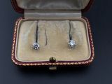 a pair of diamond earrings in a case on a table