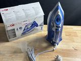 a blue and white iron sitting on top of a wooden table