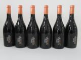six bottles of wine are lined up in a row on a white surface