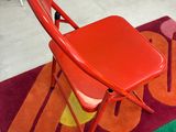 une chaise rouge posée sur un tapis coloré dans une pièce