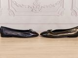 two pairs of black shoes sitting on top of a wooden floor