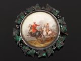 a picture of a broochle with a picture of a man riding a horse