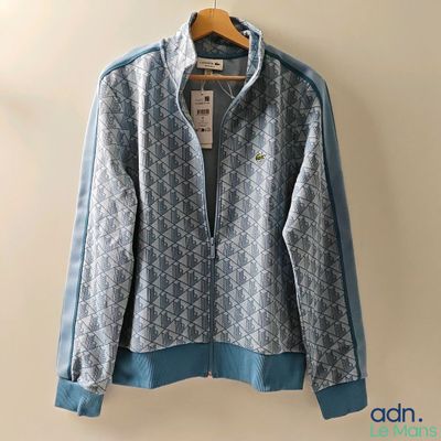 une veste bleue et blanche accrochée au mur à côté d'un cintre