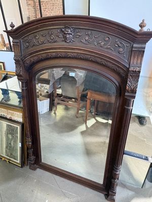 a mirror that is sitting on the floor next to a chair