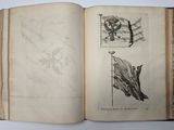 an open book with drawings on it on a table