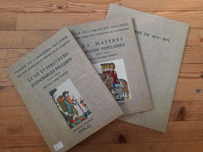 trois livres posés sur une table en bois, l'un à côté de l'autre