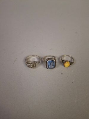 three rings with a blue topaz stone and a yellow topaz stone