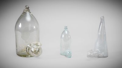 three empty glass bottles and one empty glass bottle on the table