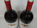 two bottles of wine sitting on top of a counter next to each other
