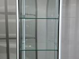 a glass display case in the corner of a room
