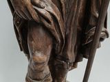 an old statue of a man with a staff and a hat