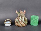 trois objets d'art en verre posés sur une table sur laquelle se trouve une bague