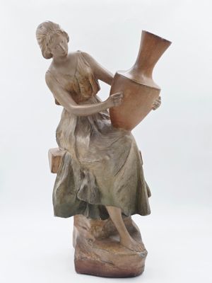 une statue représentant une femme tenant un vase sur un rocher
