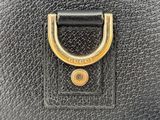 a close up of a black purse with a gold handle
