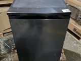 an image of a black refrigerator sitting on a pallet in a warehouse
