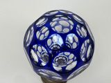 a blue glass knob with white dots on it