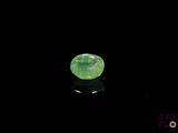 a close up of a green gemstone on a black surface