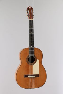 un gros plan d'une guitare accrochée au mur