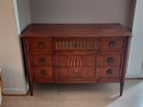 a wooden dresser in the corner of a living room