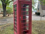 une cabine téléphonique rouge au milieu d'un champ