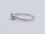 a white gold ring with a blue topaz stone and diamonds