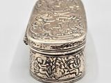 an antique silver box with a floral design on the lid