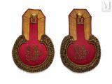 pair of red and gold badges with gold trims on a white background