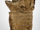 une image représentant un vase en forme de tête de pierre sur lequel est représenté un visage