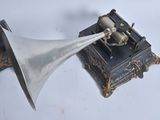 a silver trumpet sitting on top of a wooden box