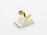 a close up of a gold ring with a green stone