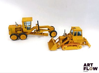 deux engins de chantier miniatures posés l'un à côté de l'autre