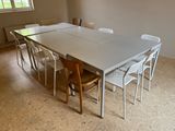 une table et des chaises dans une pièce avec une grande fenêtre