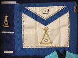 a blue and white apron with a masonic emblem on it