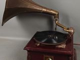 un petit gramophone ancien posé sur un socle en bois